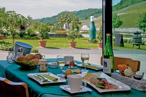 尼特尔Gästehaus und Weingut Bernd Frieden的一张桌子,上面有带食品和酒杯的绿桌布