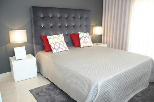 珀彻斯Apartamento luminoso Urb. Quinta das Palmeiras的一间卧室配有一张带红色枕头的大床