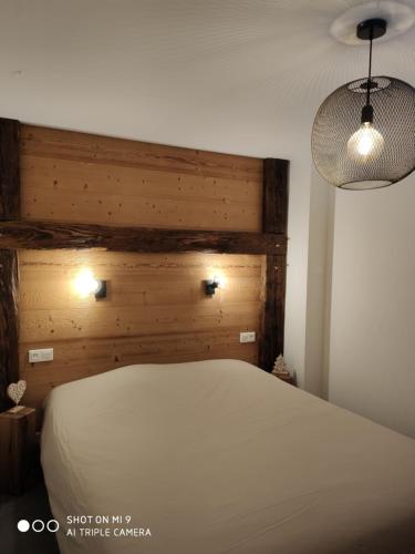 拉布雷斯LA BRESSE - Appartement de Charme的卧室配有白色的床和木制床头板