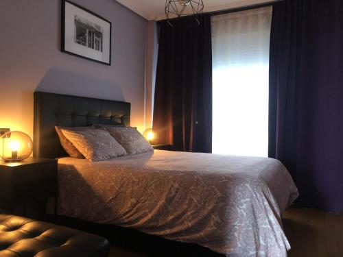 拉科鲁尼亚PARKING, vistas al MAR y tres habitaciones的一间卧室设有一张大床和一个窗户。