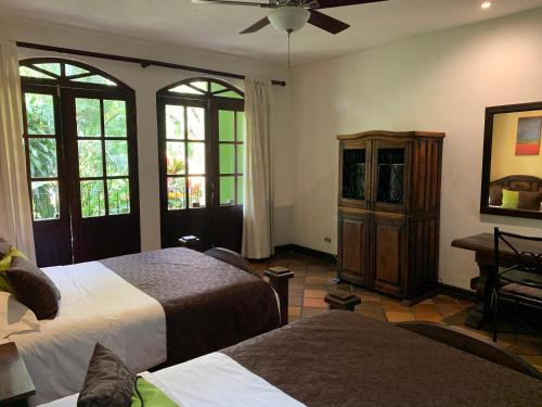 San Antonio特拉普家庭乡村旅馆的一间卧室设有两张床、一个梳妆台和窗户。