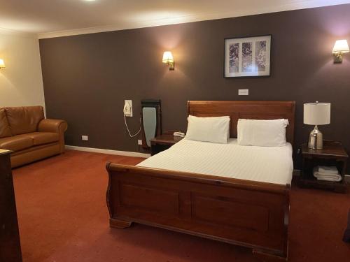 利灰狗酒店的一间卧室配有一张床、一张沙发和一部电话
