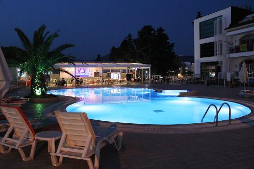 马尔马里斯Forum Residence Hotel的一座带两把椅子的大型游泳池和一座建筑