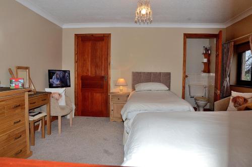 英格尔顿Nutstile Farm Bed and Breakfast的酒店客房 - 带两张床、一张桌子和一张床