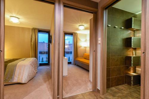 巴拉顿菲赖德Villapark Luxury Apartman Balatonfüred的一间酒店客房,配有一张床和一个玻璃门
