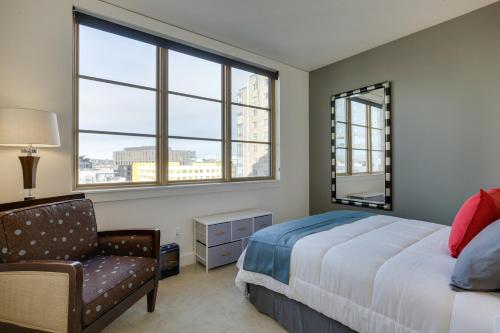 波特兰Renu Suites at The Burlington Portland的一间卧室配有一张床、一把椅子和窗户。