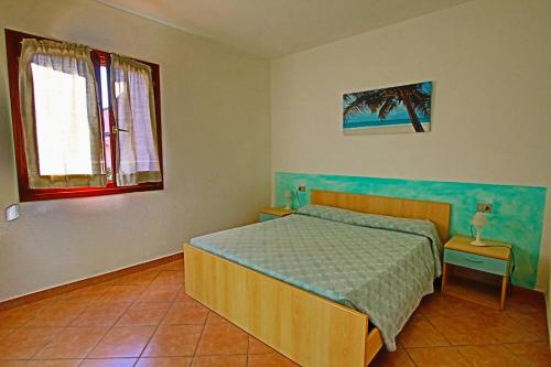 圣特奥多罗Residence Stella Marina的一间卧室设有一张床和两个窗户。