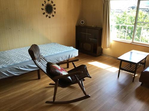 真庭市富乃亭的一间卧室配有椅子、一张床和一张桌子
