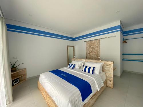 艾湄湾Kura Kura Divers Lodge的一间卧室配有一张蓝色和白色条纹的床