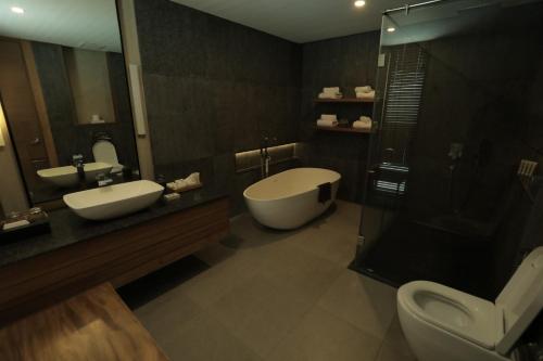大雅台Escala Tagaytay的一间带两个盥洗盆、淋浴和卫生间的浴室