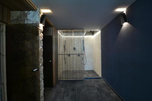 巴尔奇克Boutique Hotel by BlackSeaRama的走廊上设有淋浴,房间设有蓝色的墙壁