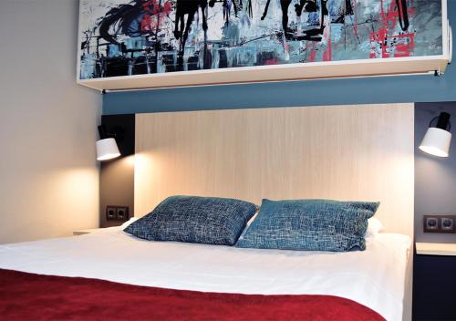 默恩达尔默恩达尔早安酒店的一间卧室配有一张带两个蓝色枕头的床