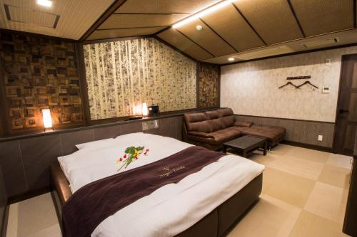 堺市ホテル アンジュエトワール 堺 - Adult Only的一间卧室配有一张大床和一把椅子