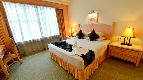 双溪大年翡翠布蒂里酒店的一间卧室设有一张床和一个大窗户