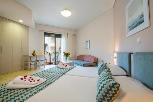 斯塔罗斯克里特棕榈度假及公寓酒店的酒店客房设有床和客厅。