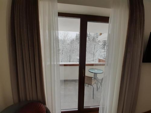 锡纳亚Nobila Sinaia的客房设有玻璃门,享有阳台的景色