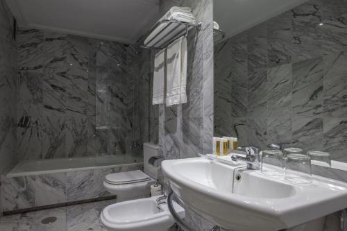 马德里Porcel Torre Garden的浴室配有盥洗盆、卫生间和浴缸。