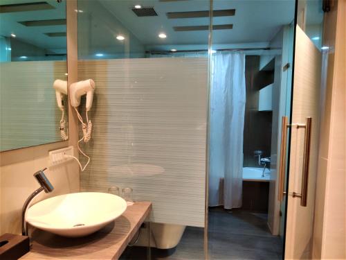 塞恩萨特卡居所酒店的一间带水槽和玻璃淋浴的浴室
