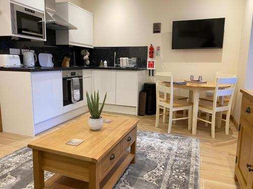 因弗内斯Waverley Inn Holiday Apartments的客厅设有厨房和桌子