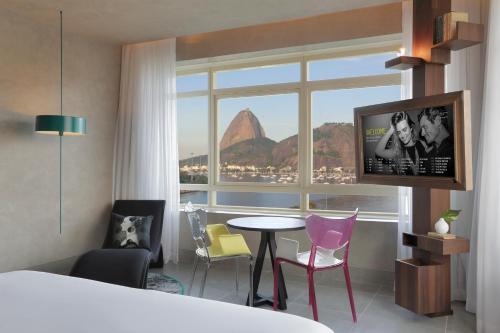 里约热内卢优2里约热内卢因特西迪酒店的酒店客房设有桌椅和窗户。