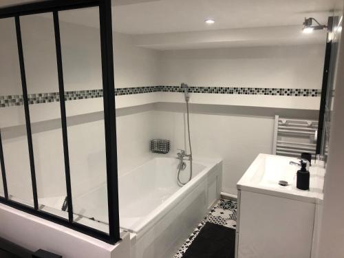 波尔多Jardin de la Béchade的白色的浴室设有浴缸和水槽。