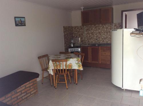 里奥格兰德Pousada do Mar的厨房配有桌椅和冰箱。