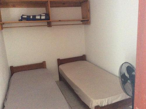 里奥格兰德Pousada do Mar的小房间设有两张床和风扇