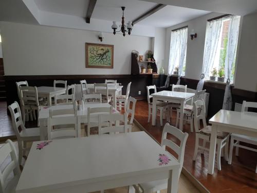 Poiana MăruluiHOTEL HO2 POIANA MARULUI的用餐室配有白色的桌子和白色的椅子