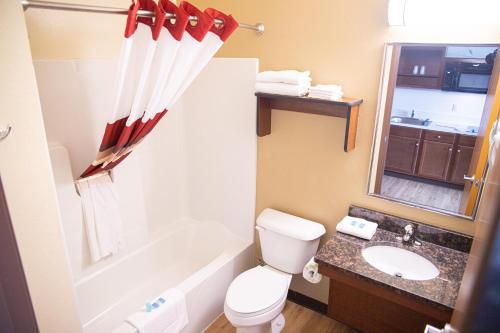 普兰菲尔德白楼套房酒店的浴室配有卫生间、浴缸和水槽。