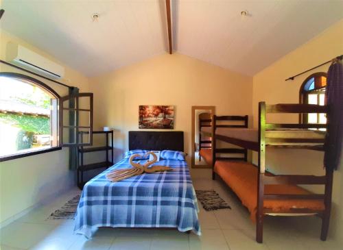 博西坎加Morada dos Colibris的一间卧室配有一张带蓝色毯子的床铺和双层床。