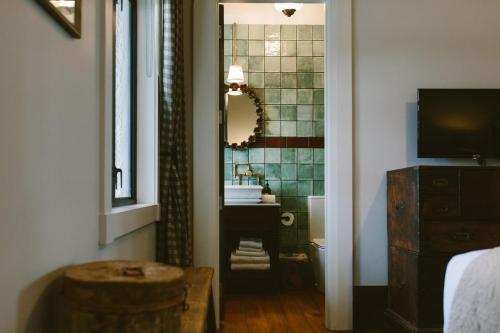 奥克兰The Convent Hotel的一间带水槽、卫生间和镜子的浴室