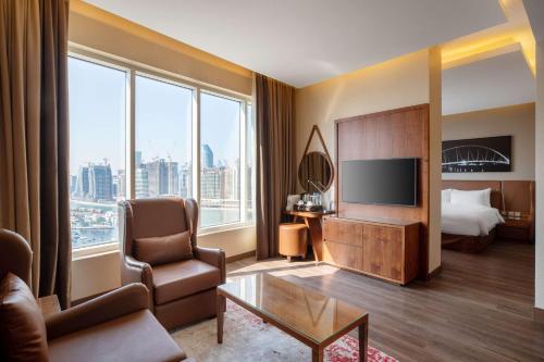 迪拜Radisson Blu Hotel, Dubai Canal View的酒店客房,配有床和电视