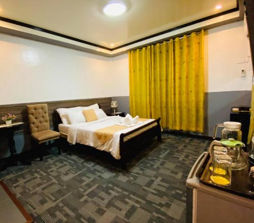 马尼拉马卡提阿麦克斯宾馆的一间卧室配有床和黄色窗帘