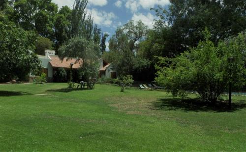 查克拉斯德科里亚La casita en el parque的一座有房子、树木和草地的院子
