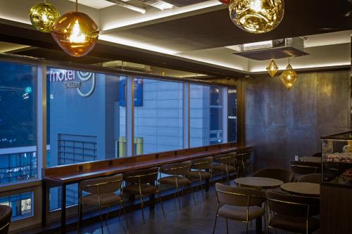 釜山Busan Lounge 26 Hotel的餐厅设有酒吧,配有桌椅