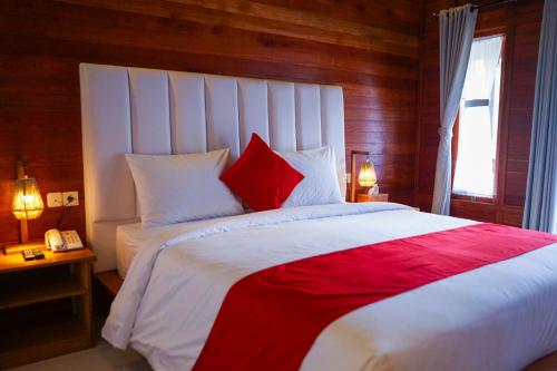 龙目岛库塔La'villaris hotel & resto的一间卧室配有一张带红色和白色枕头的大床