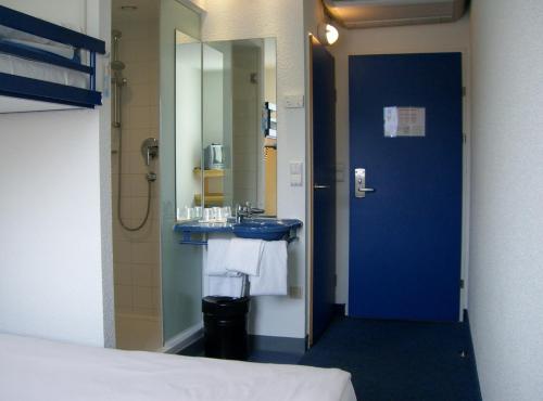 格拉茨格拉茨城宜必思快捷酒店的浴室设有蓝色水槽和镜子