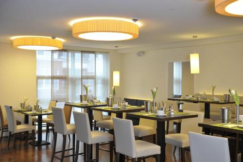 汉堡黑科托城市公园住宿酒店的用餐室设有桌椅和窗户。
