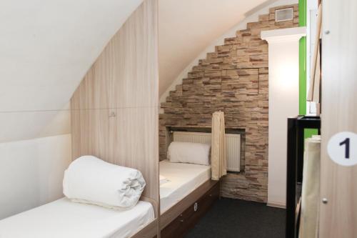 喀山Hostel Krolichya Nora的小房间设有两张床和砖墙