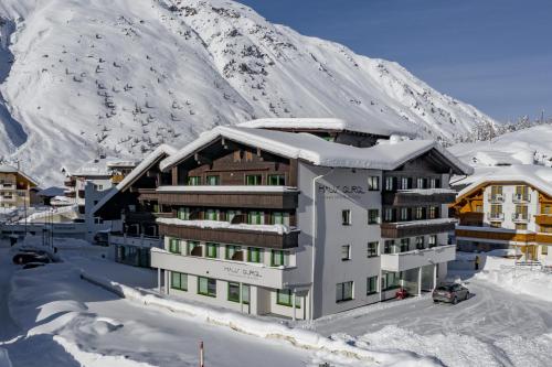 奥伯古格尔Skihotel Haus Gurgl的山前的雪中酒店