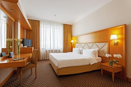 莫斯科莫斯科米兰酒店的配有一张床和一张书桌的酒店客房