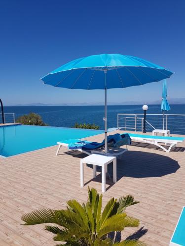 SpartosIris Villas的游泳池旁的蓝伞