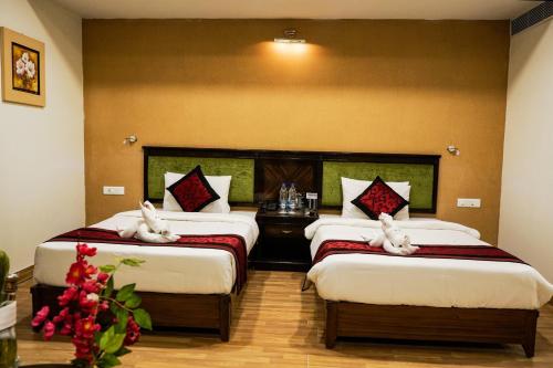 瓜廖尔Hotel Adityaz的在酒店房间设有两张床,里面装满了动物