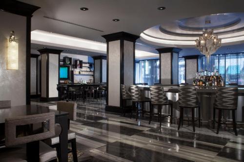 芝加哥Silversmith Hotel Chicago Downtown的餐厅设有酒吧,配有凳子和桌子