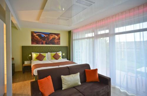 San NazzaroLa Campagnola - Top Swiss Family Hotel的一间卧室配有一张床、一张沙发和一个窗口