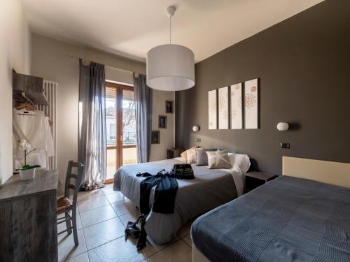 加比切马莱Appartamenti Villa Tonni的一间卧室设有两张床和大窗户