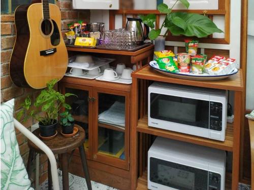 曼谷The Little Cottage 47的带微波炉和吉他的厨房