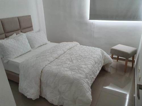 库库塔Excelente Apartamento Completo, en la mejor zona的白色卧室配有床和椅子
