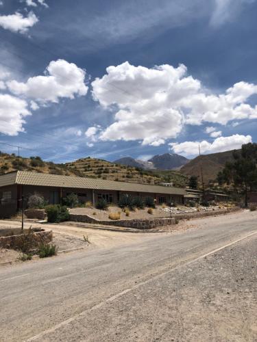 普特雷Hotel Las Vicuñas的一条空的路,在一座有山的建筑前