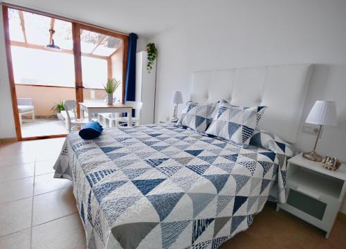 大塔拉哈尔Atlantic Sea的一间卧室配有一张带蓝色和白色被子的床